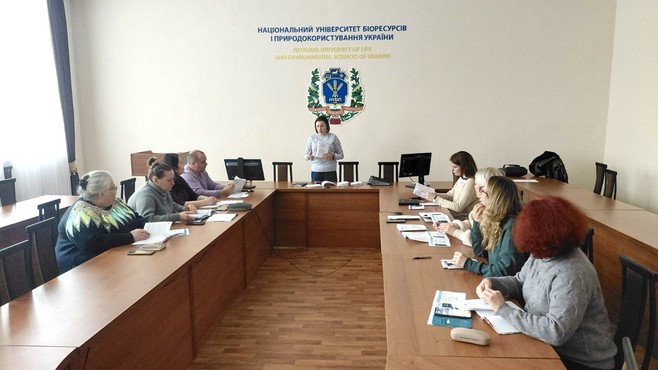 A person standing in front of a group of people sitting at a table</p>
<p>AI-generated content may be incorrect.