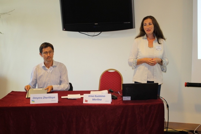 A person and person standing at a tableDescription automatically generated