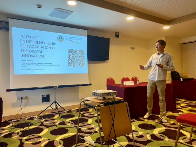 A person standing in front of a projector screenDescription automatically generated