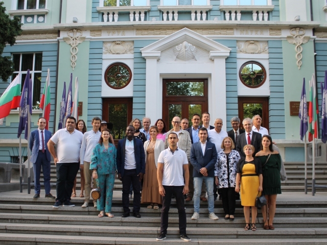 A group of people standing on steps in front of a buildingDescription automatically generated